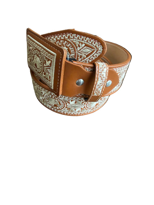 Brown leather strap with intricate patterns on a wooden surface